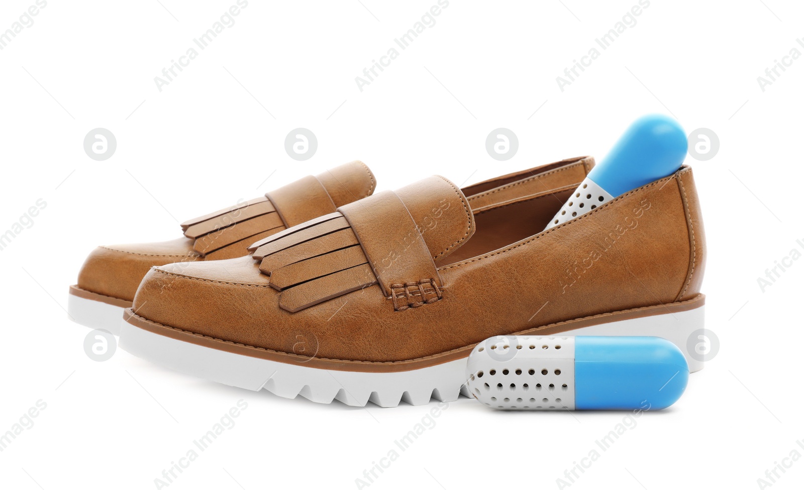 Photo of Shoes with capsule fresheners on white background