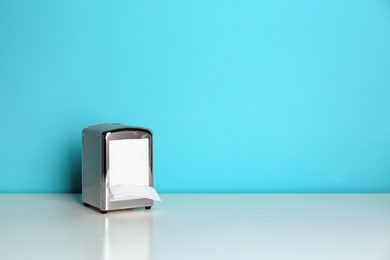 Napkin holder with paper serviettes on table. Space for text