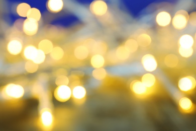 Photo of Blurred view of Christmas lights on table