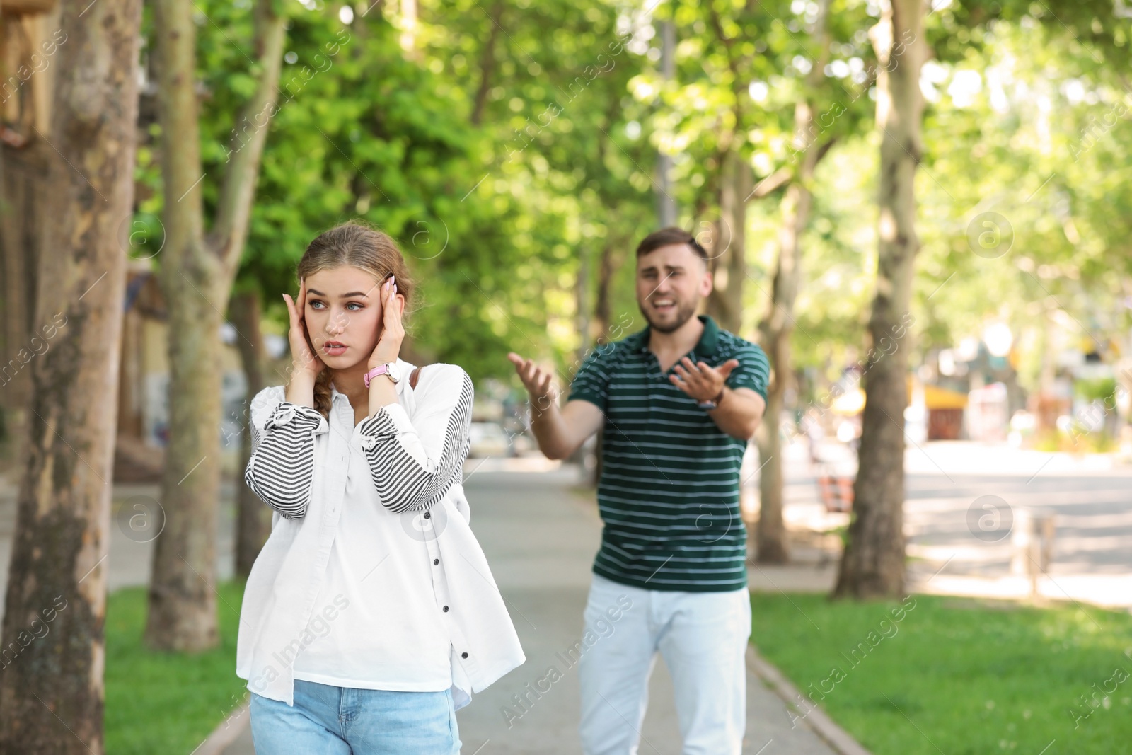 Photo of Young couple arguing on street. Problems in relationship