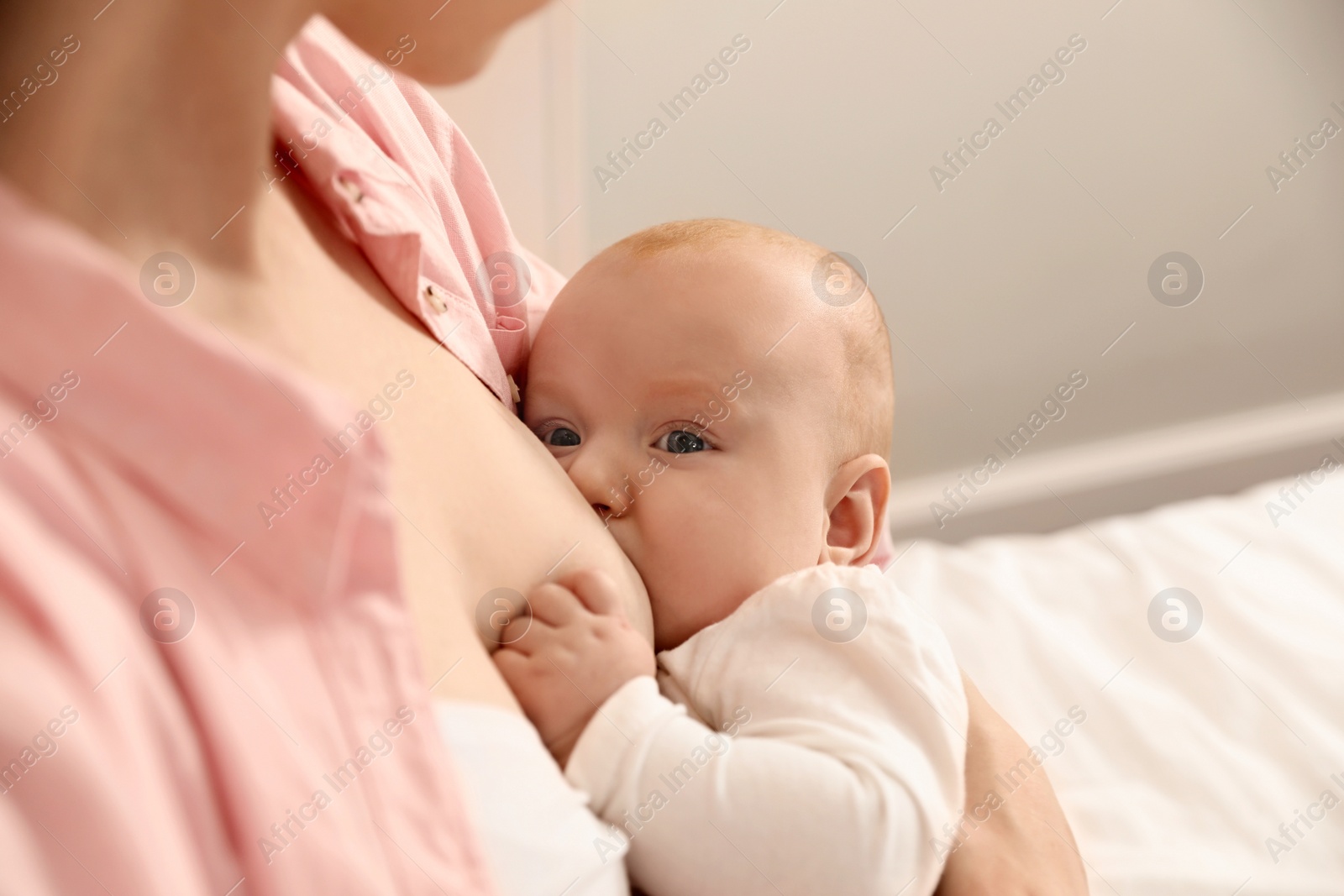 Photo of Young woman breast feeding her little baby, closeup