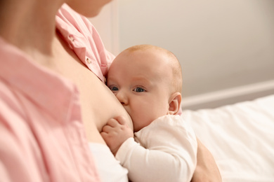 Photo of Young woman breast feeding her little baby, closeup