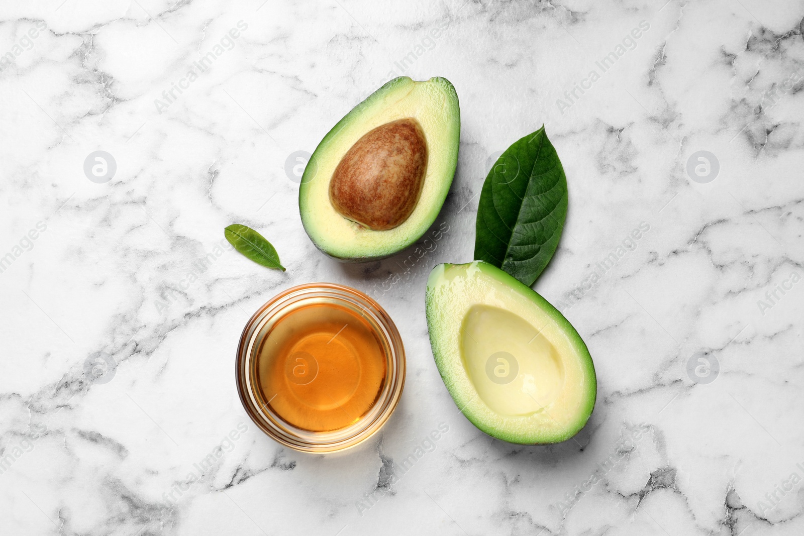 Photo of Flat lay composition with essential oil and avocado on white marble table