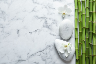 Photo of Flat lay composition with green bamboo stems on marble background. Space for text