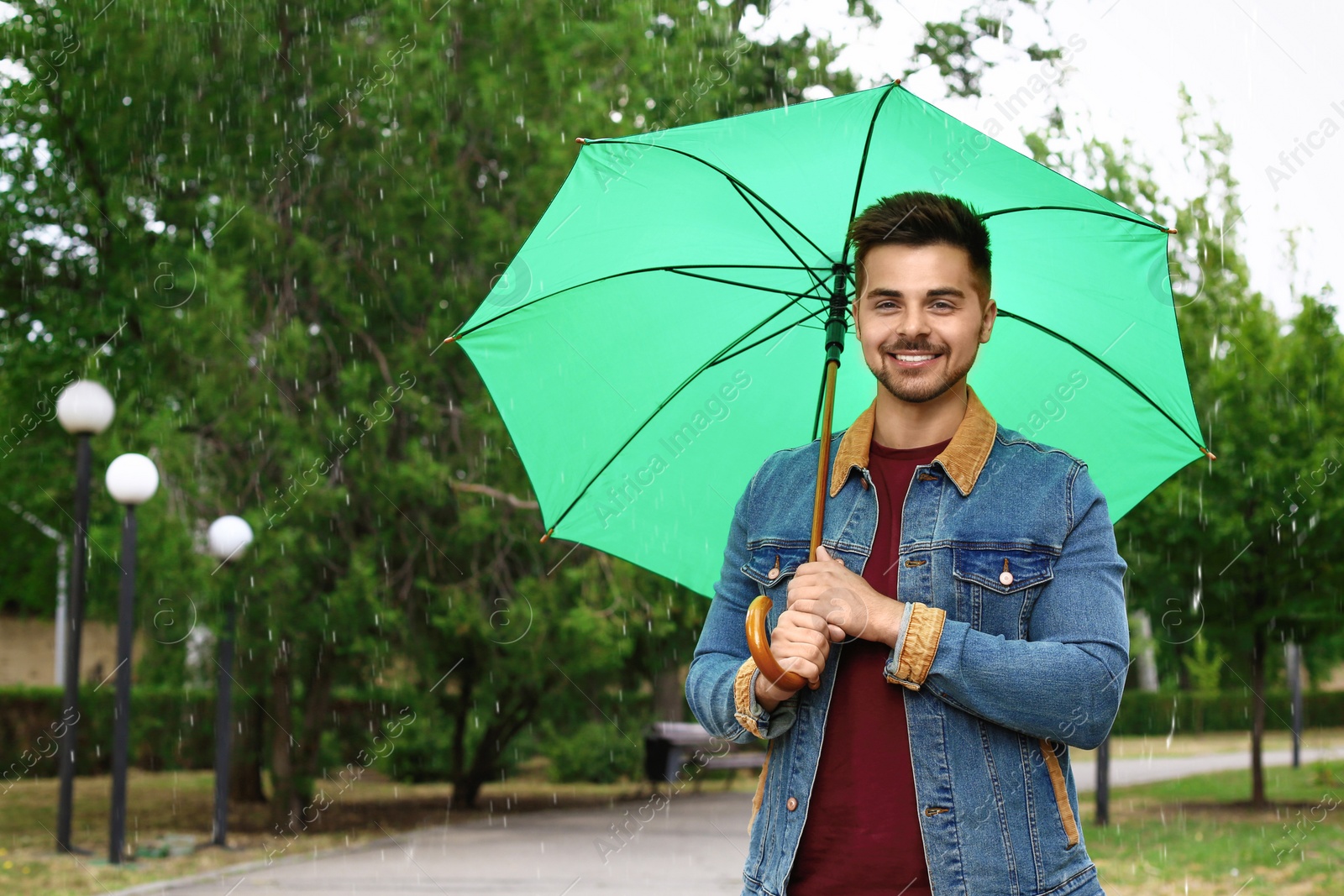 Photo of Man with umbrella outdoors on rainy day