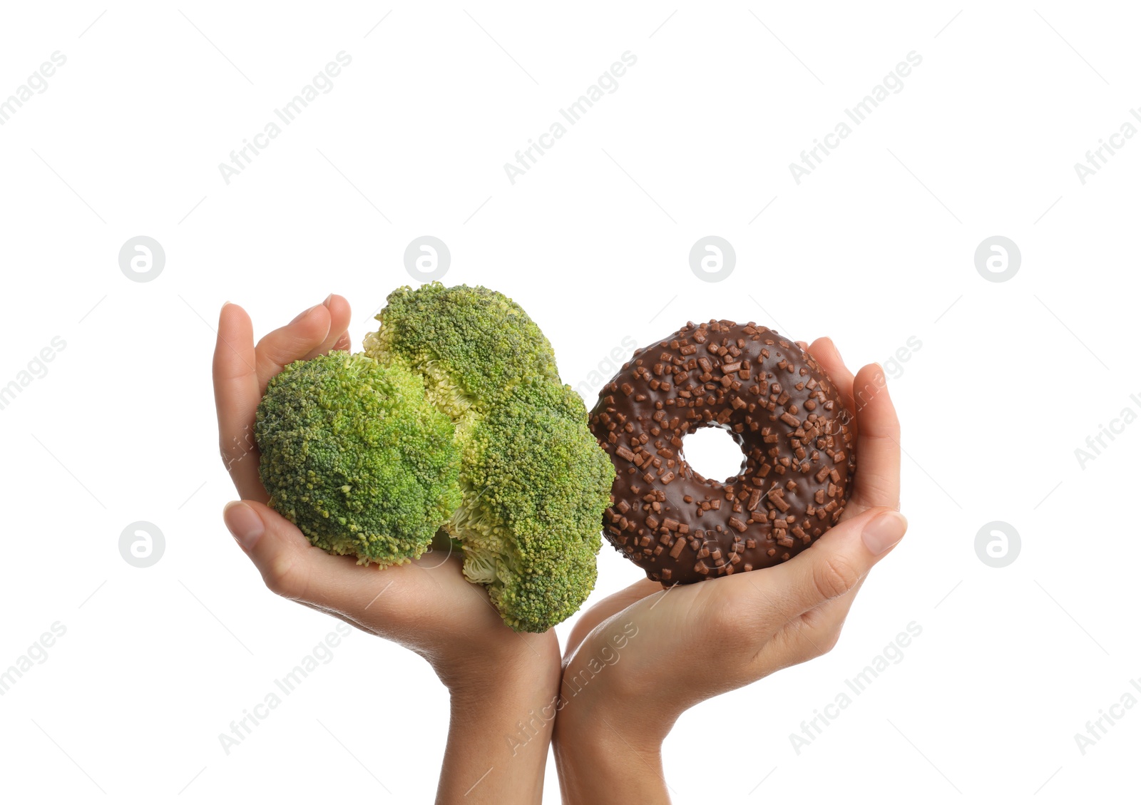 Photo of Woman choosing between doughnut and fresh broccoli on white background, closeup