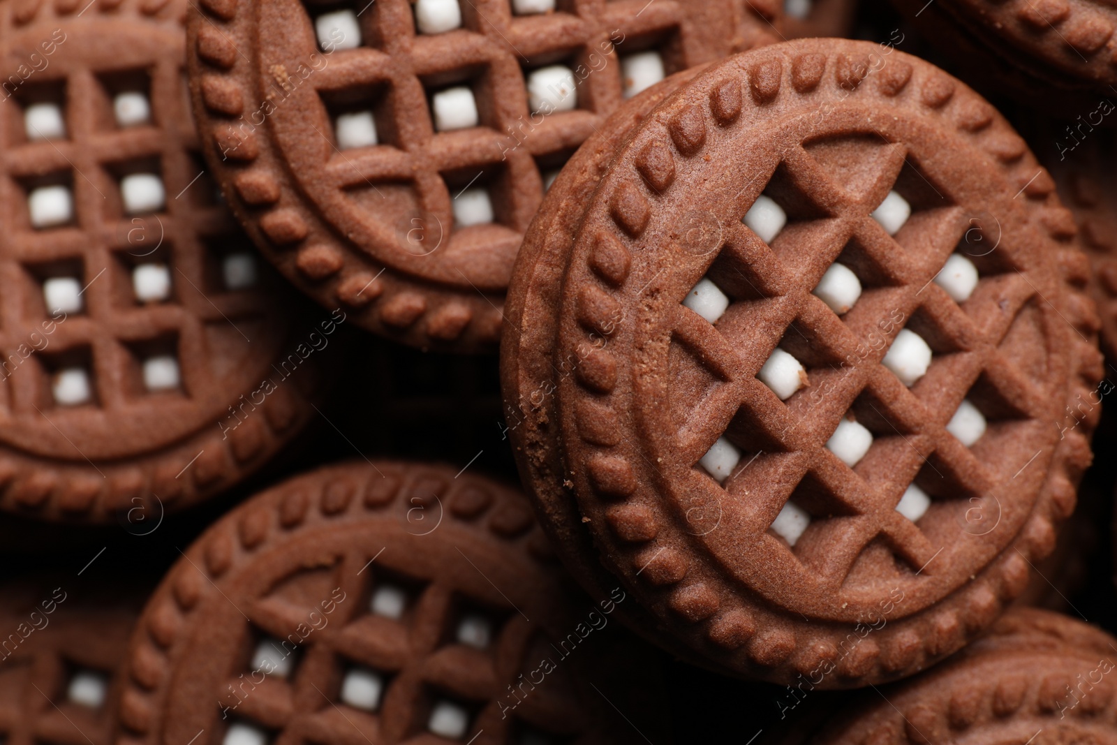 Photo of Tasty chocolate sandwich cookies with cream as background, closeup