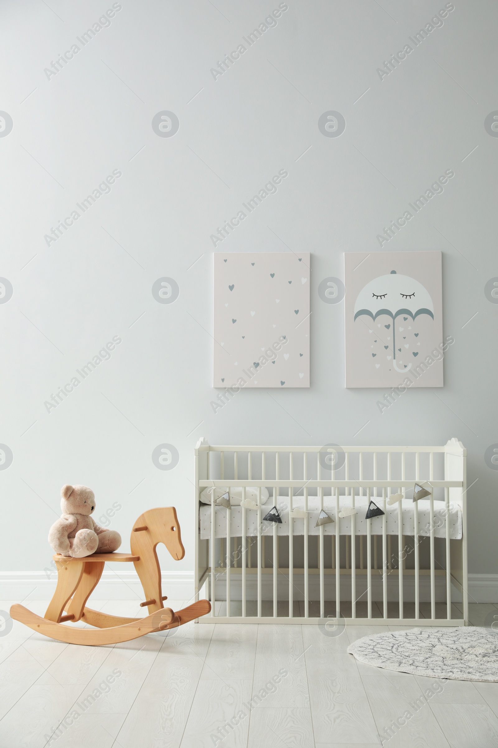 Photo of Minimalist room interior with baby crib, decor elements and toys