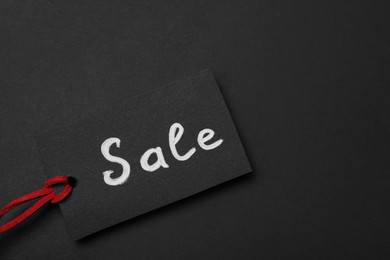 Photo of Tag with word Sale on dark background, top view and space for text. Black Friday