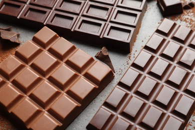 Different chocolate bars on grey background, closeup