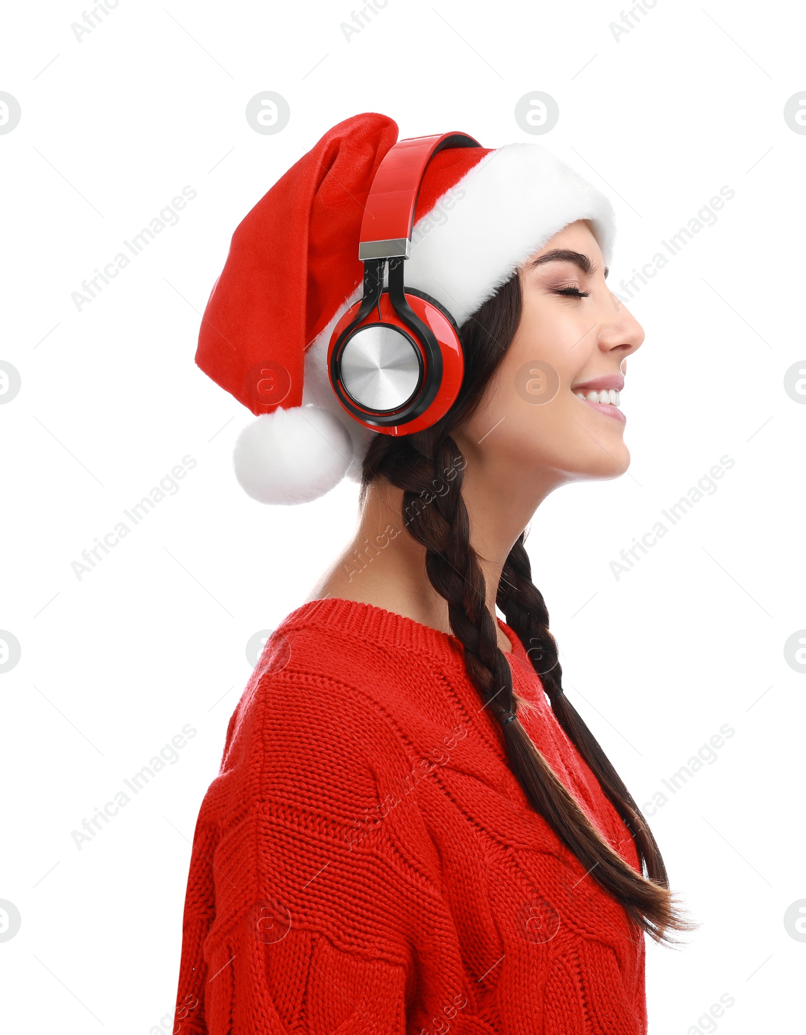 Photo of Young woman in Santa hat listening to Christmas music on white background