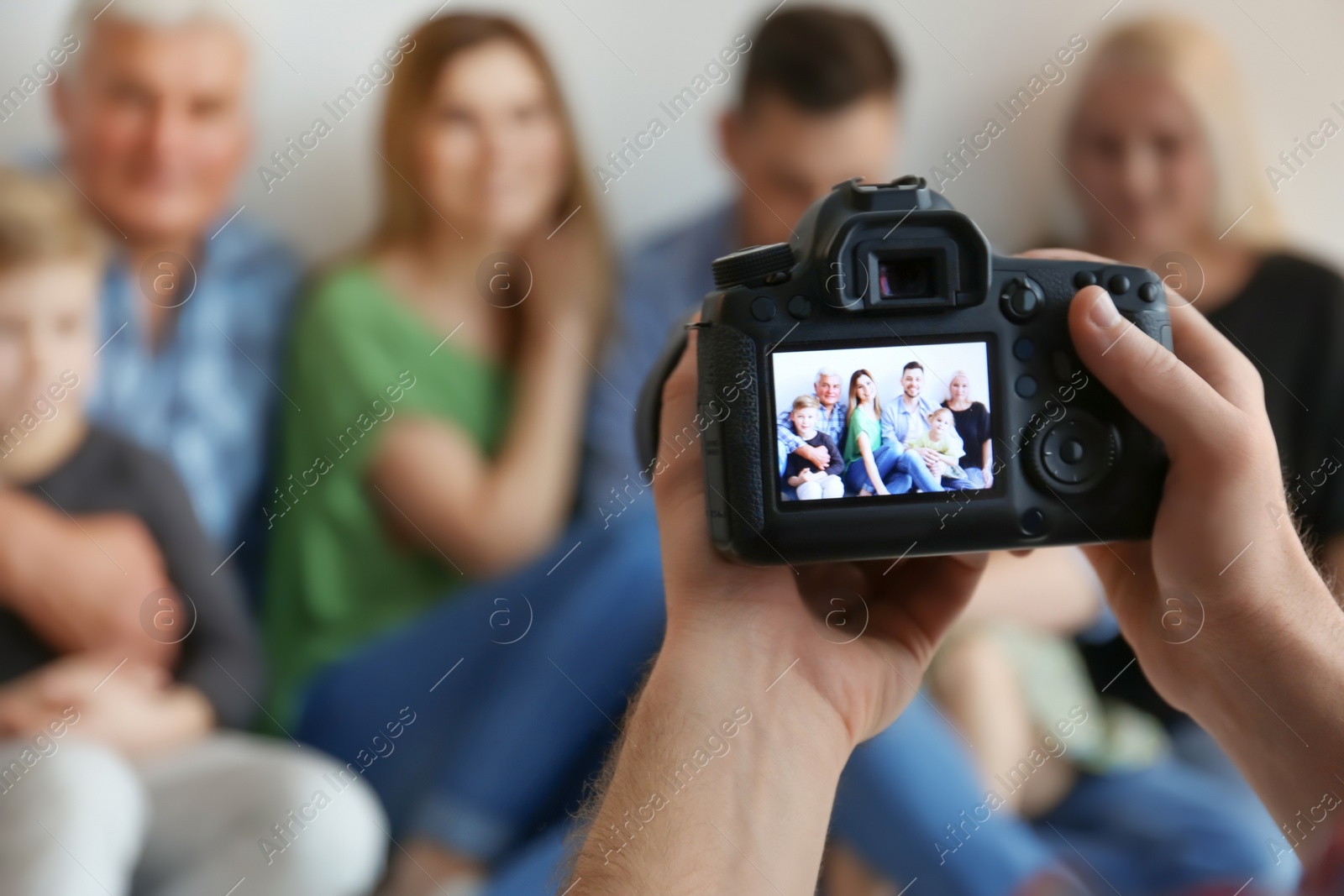 Photo of Professional photographer taking photo of family in studio