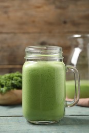 Tasty fresh kale smoothie on light blue wooden table