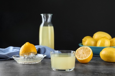 Composition with glass of freshly squeezed lemon juice on table