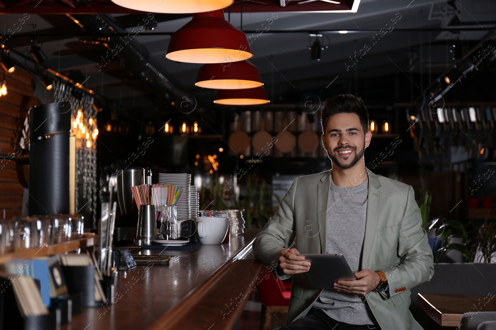 Photo of Young business owner with tablet in his cafe