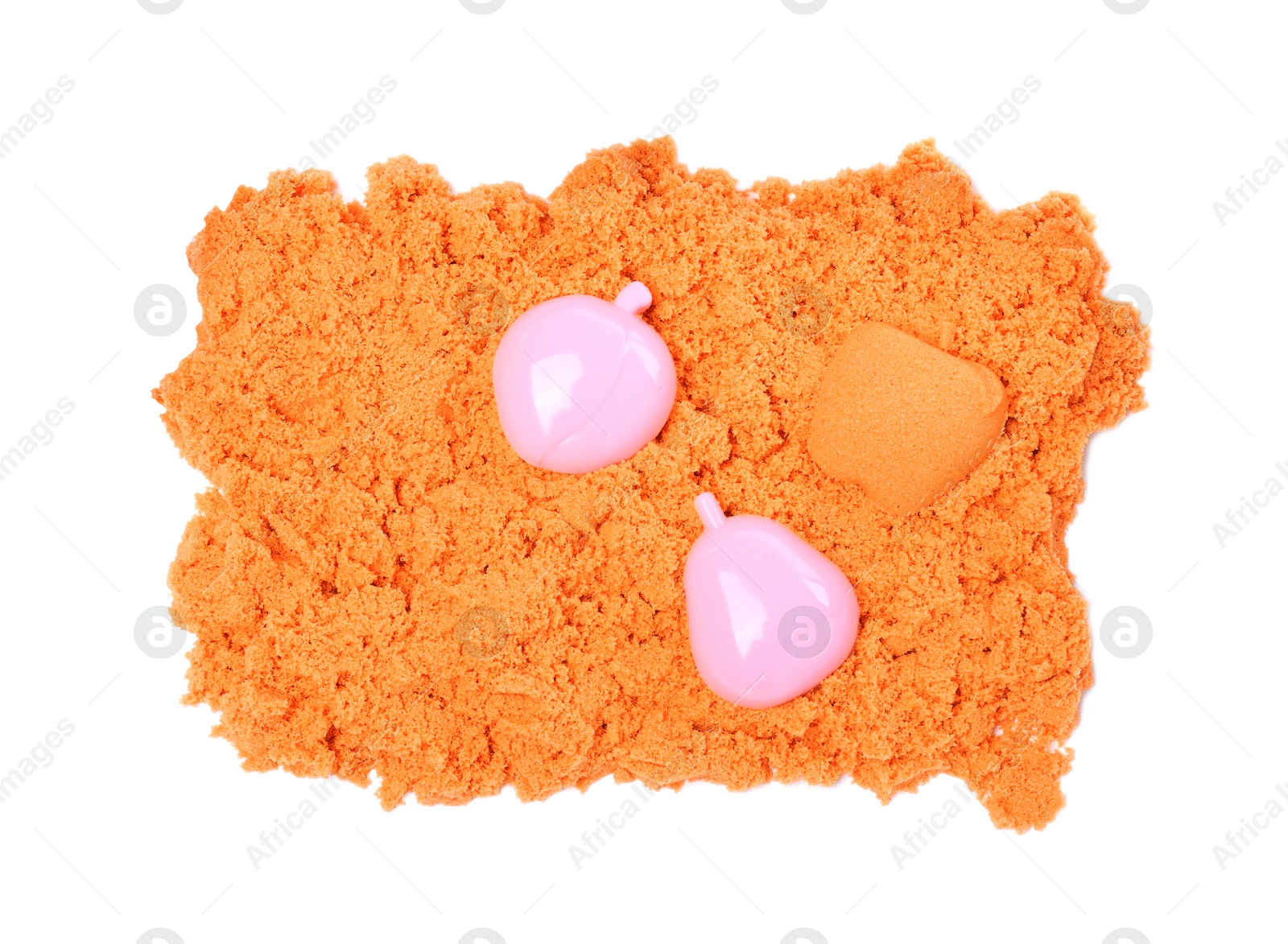 Photo of Orange kinetic sand and toys on white background, top view