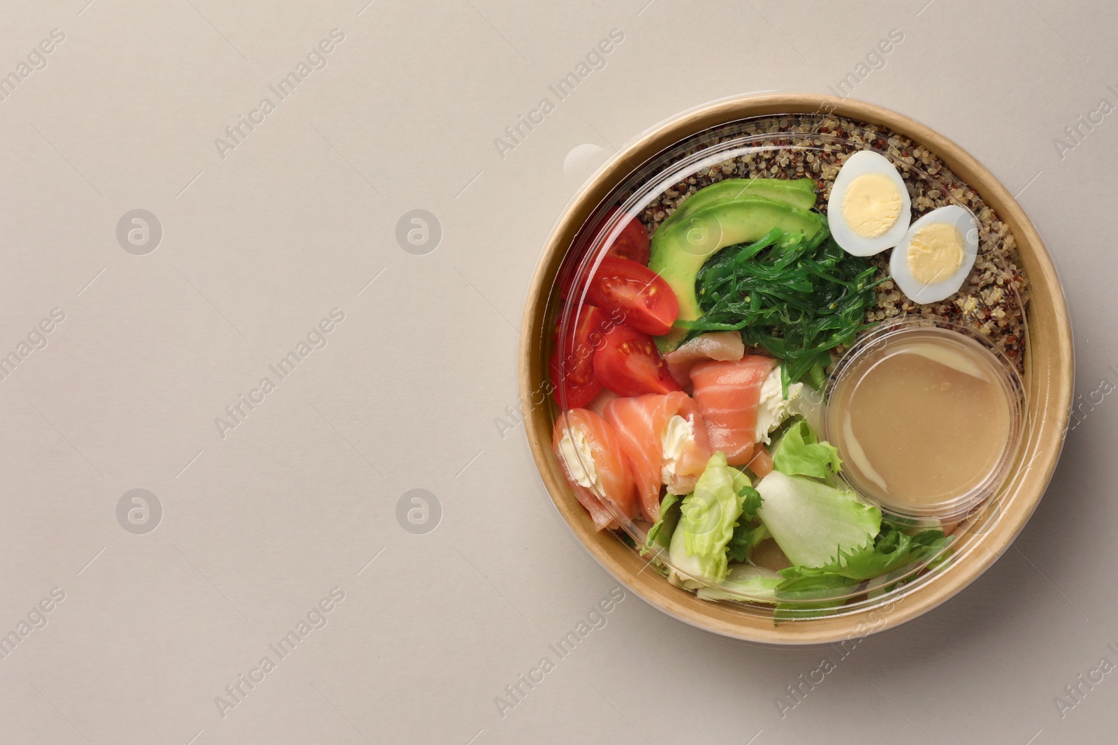 Photo of Tasty food in container on light background, top view. Space for text