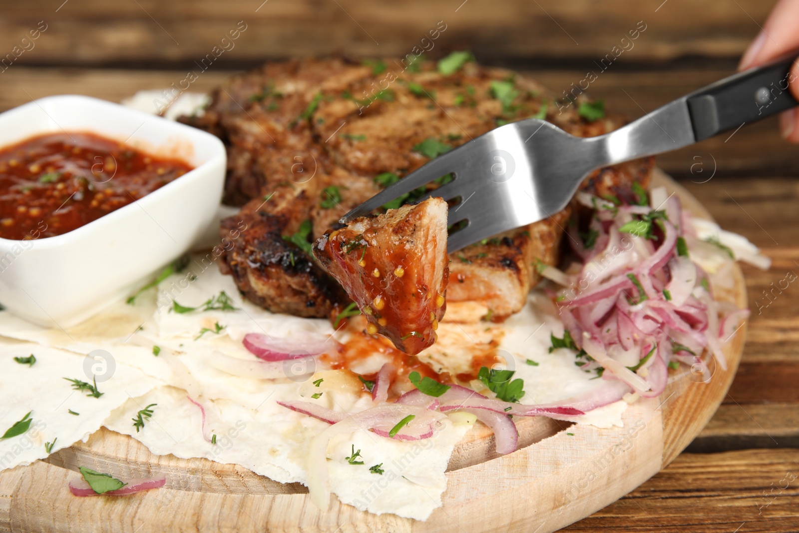 Photo of Fork with piece of delicious grilled meat, closeup