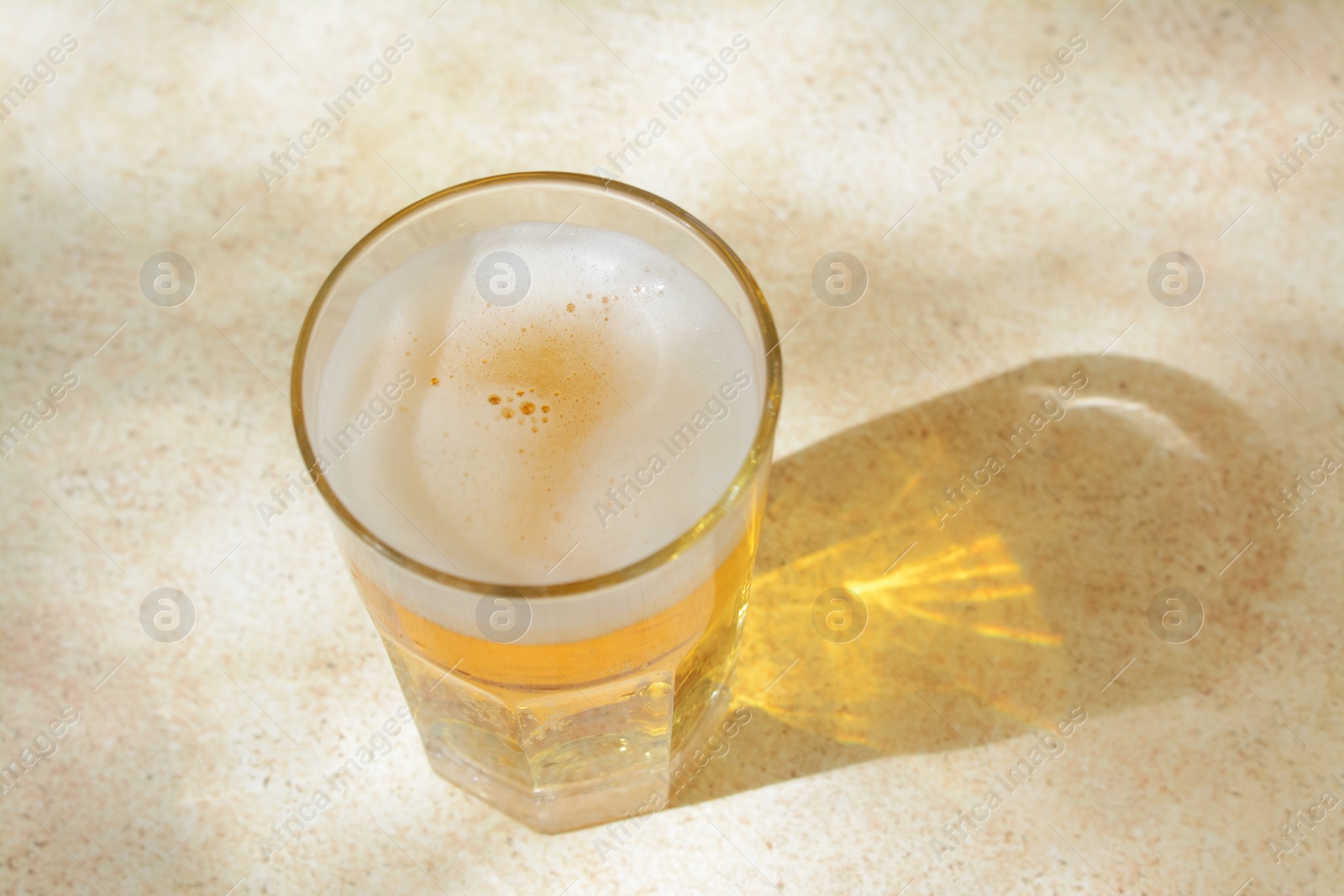 Photo of Glass with delicious beer on table, above view