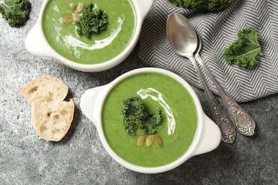 Tasty kale soup served on grey table, flat lay