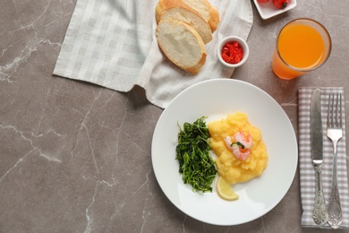 Photo of Plate with fresh tasty shrimp and grits on table