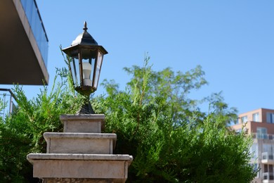 Pillar with vintage street lamp outdoors on sunny day, space for text