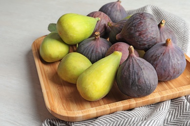 Photo of Plate with assorted ripe figs on table. Tropical fruit