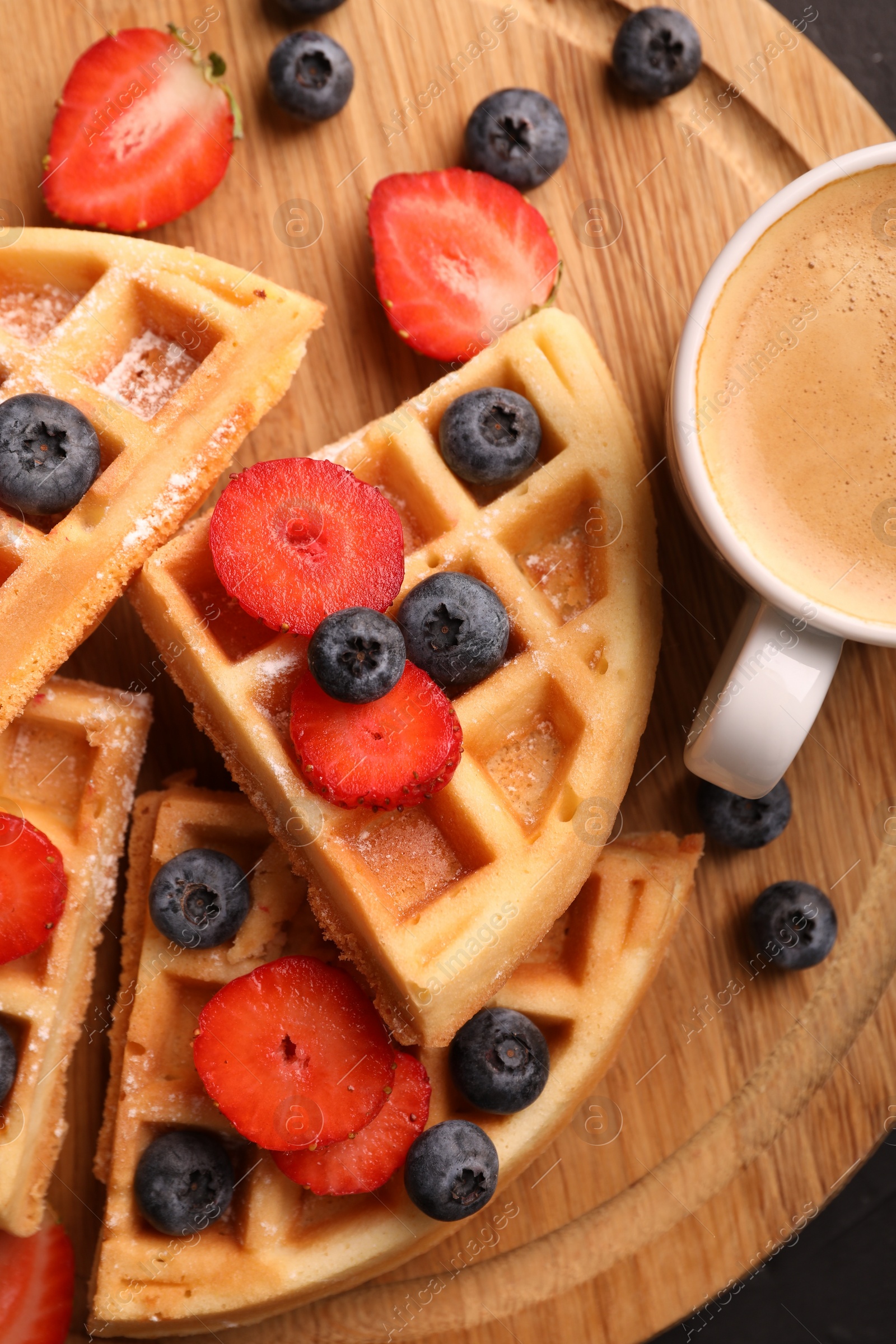 Photo of Tasty Belgian waffles with fresh berries and cup of coffee, top view