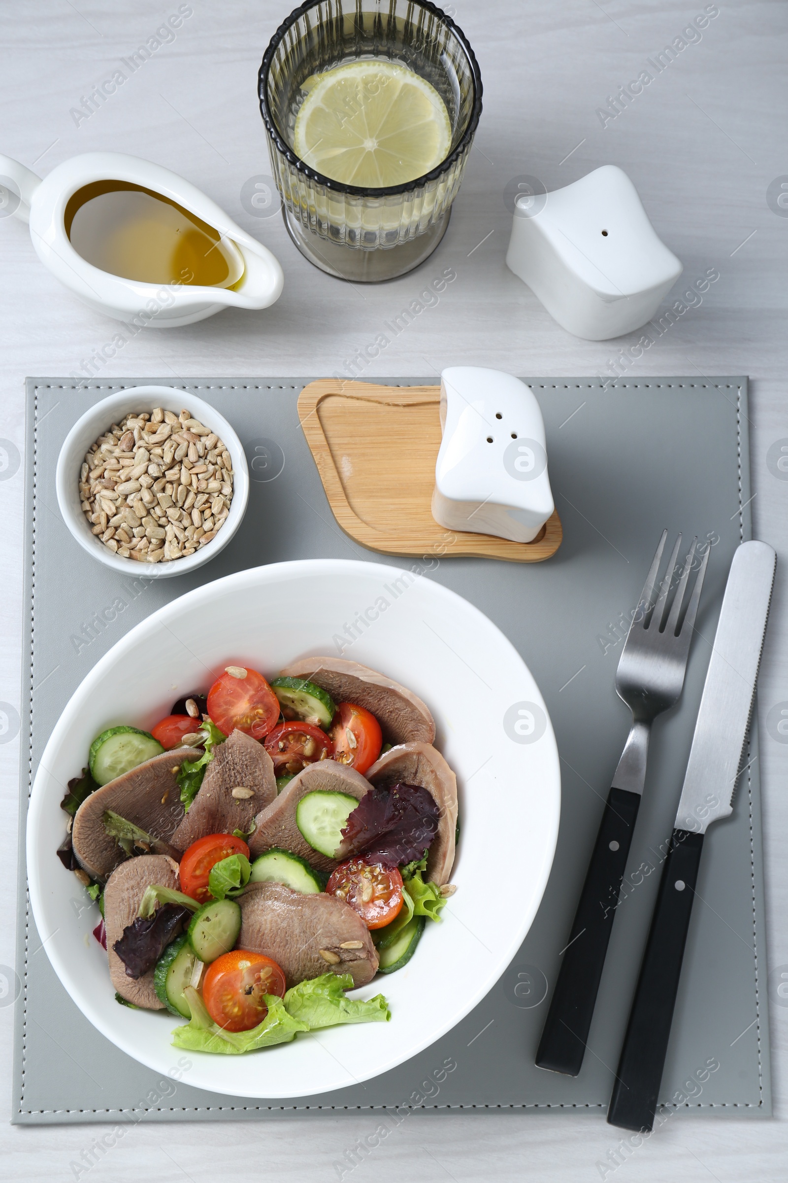 Photo of Delicious salad with beef tongue and vegetables served on white wooden table, flat lay