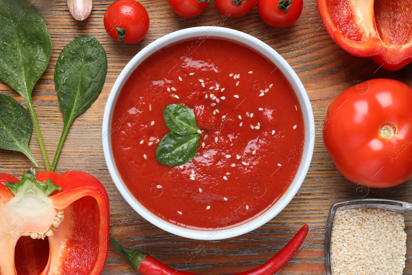 Photo of Delicious tomato sauce and ingredients on wooden table, flat lay