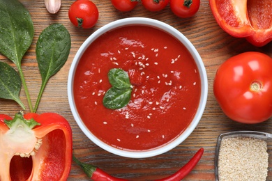 Photo of Delicious tomato sauce and ingredients on wooden table, flat lay