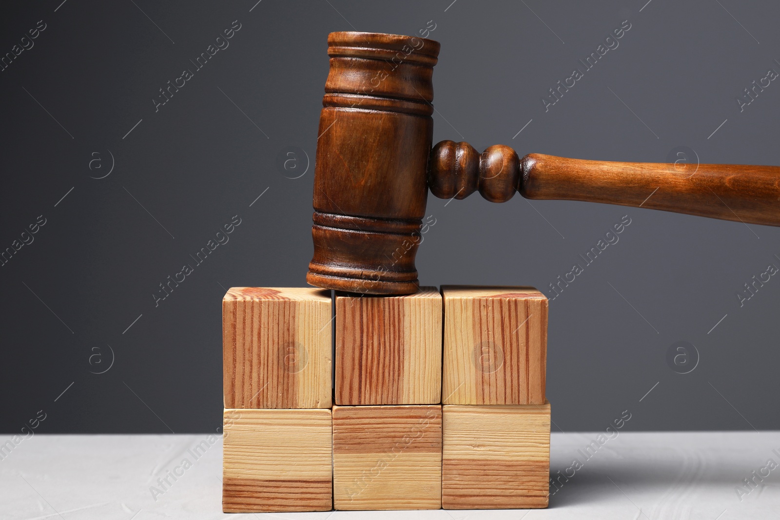 Photo of Law. Blank wooden cubes and gavel on light table against gray background
