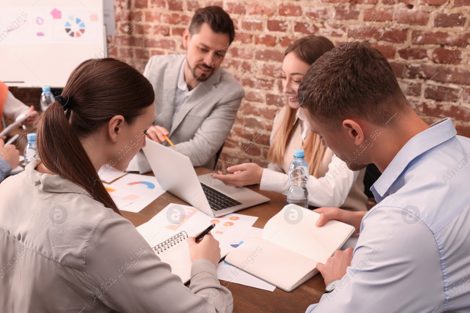 Photo of Team of employees working together in office