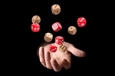 Image of Man throwing dice on black background, closeup