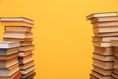 Photo of Many hardcover books on orange background, space for text. Library material