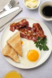 Photo of Delicious breakfast with sunny side up egg served on light table, flat lay