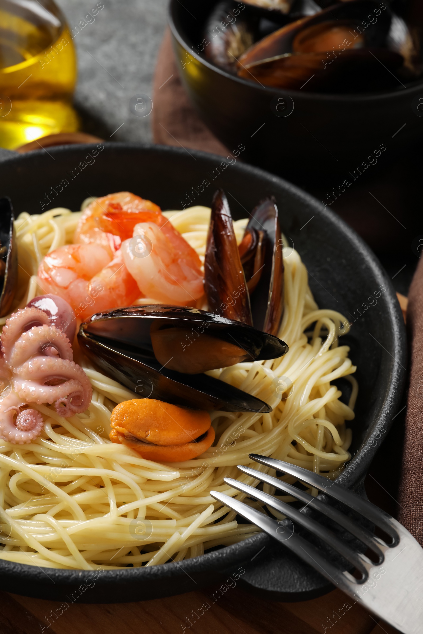 Photo of Delicious pasta with sea food served on table, closeup