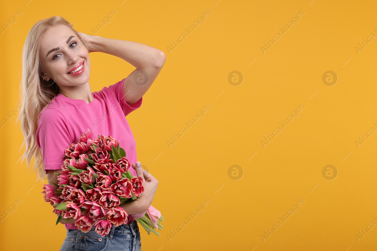 Photo of Happy young woman with beautiful bouquet on orange background. Space for text