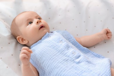 Photo of Cute little baby lying in crib at home