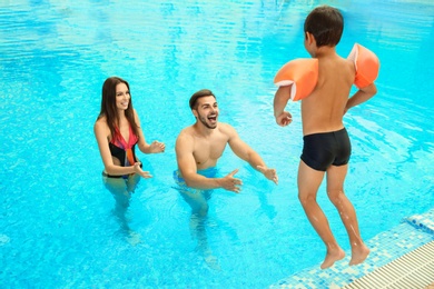 Photo of Happy family playing together in swimming pool