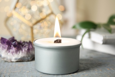 Photo of Burning candle with wooden wick on grey table