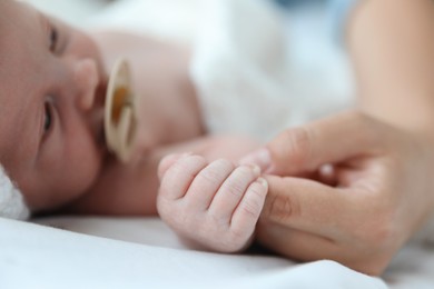 Photo of Mother and her cute newborn baby on bed, closeup