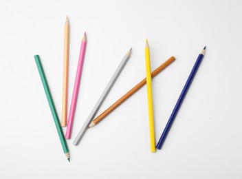 Colorful wooden pencils on white background, flat lay