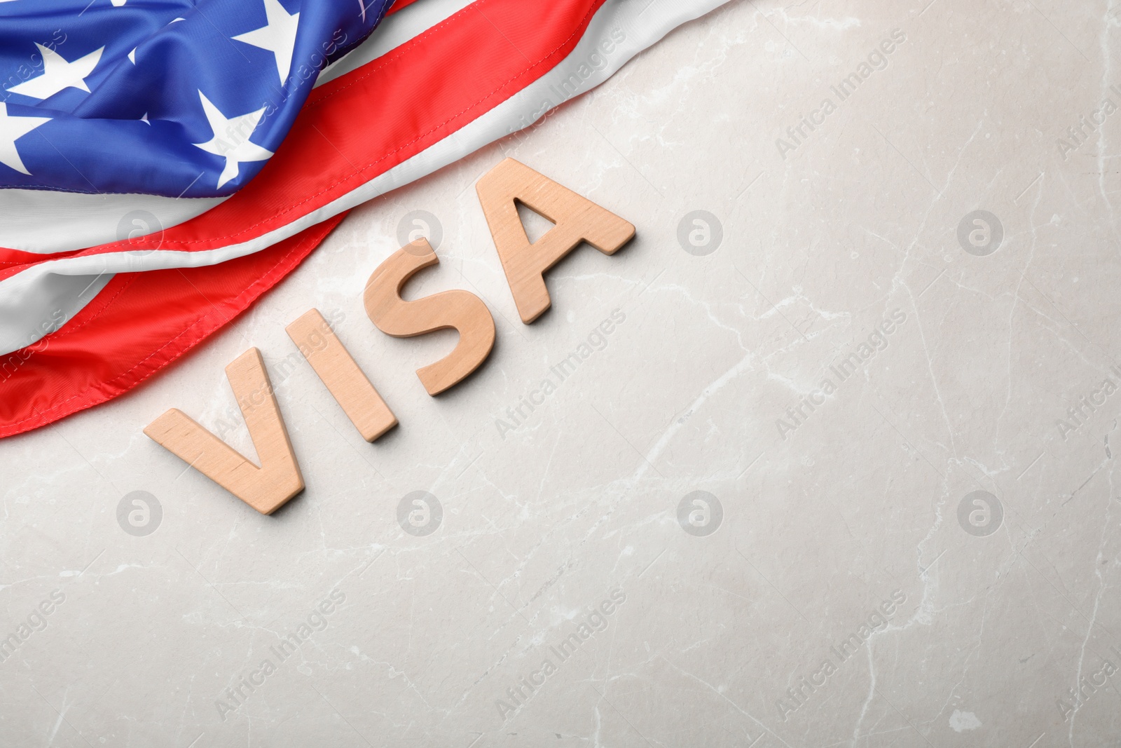 Photo of Flat lay composition with word VISA and flag of USA on gray background. Space for text