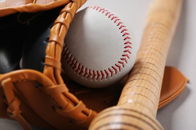 Photo of Baseball glove, bat and ball on white background, closeup