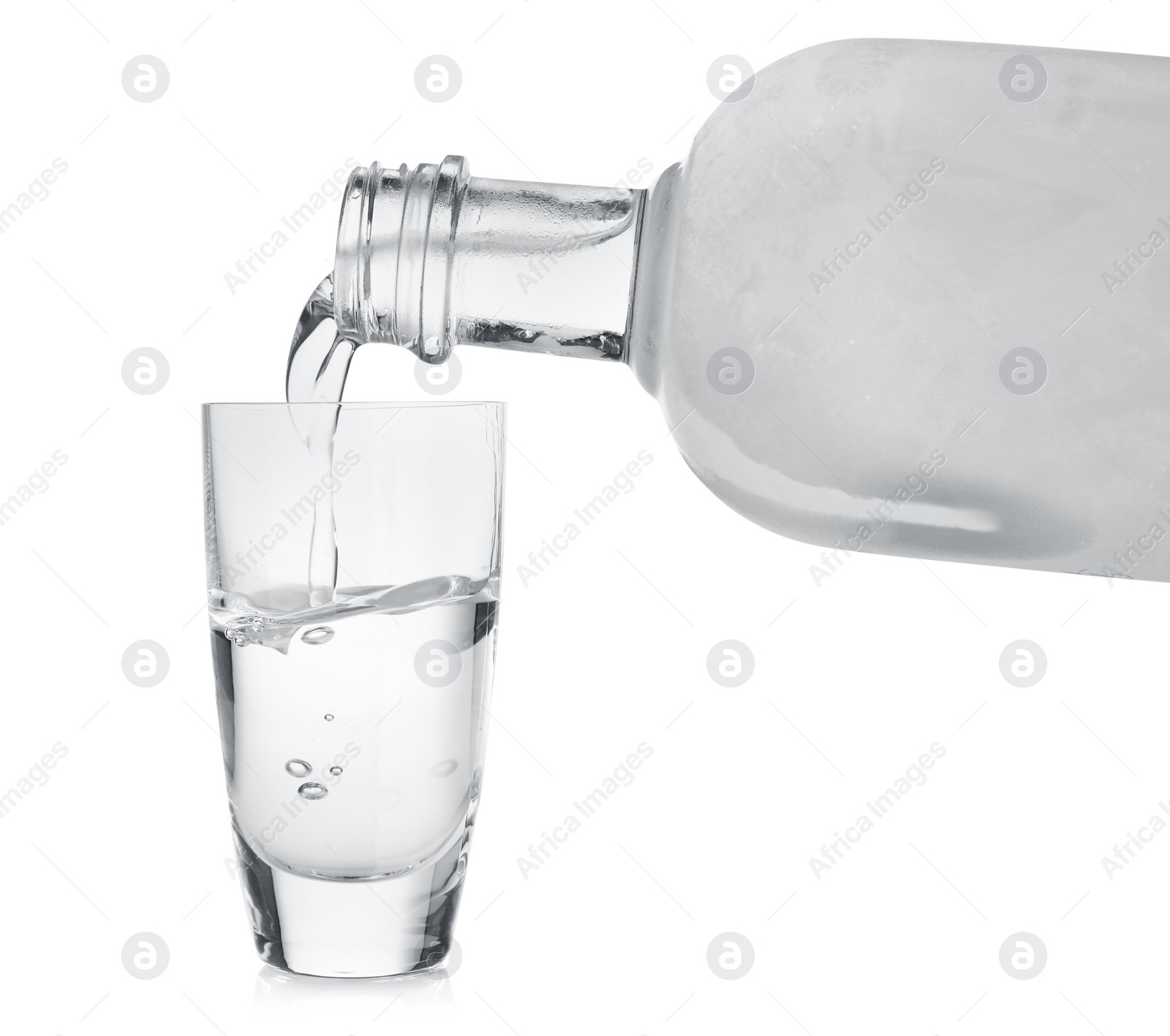Photo of Pouring cold vodka into shot glass on white background