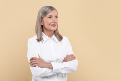 Portrait of beautiful senior woman on beige background. Space for text