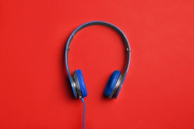 Stylish headphones on color background, top view