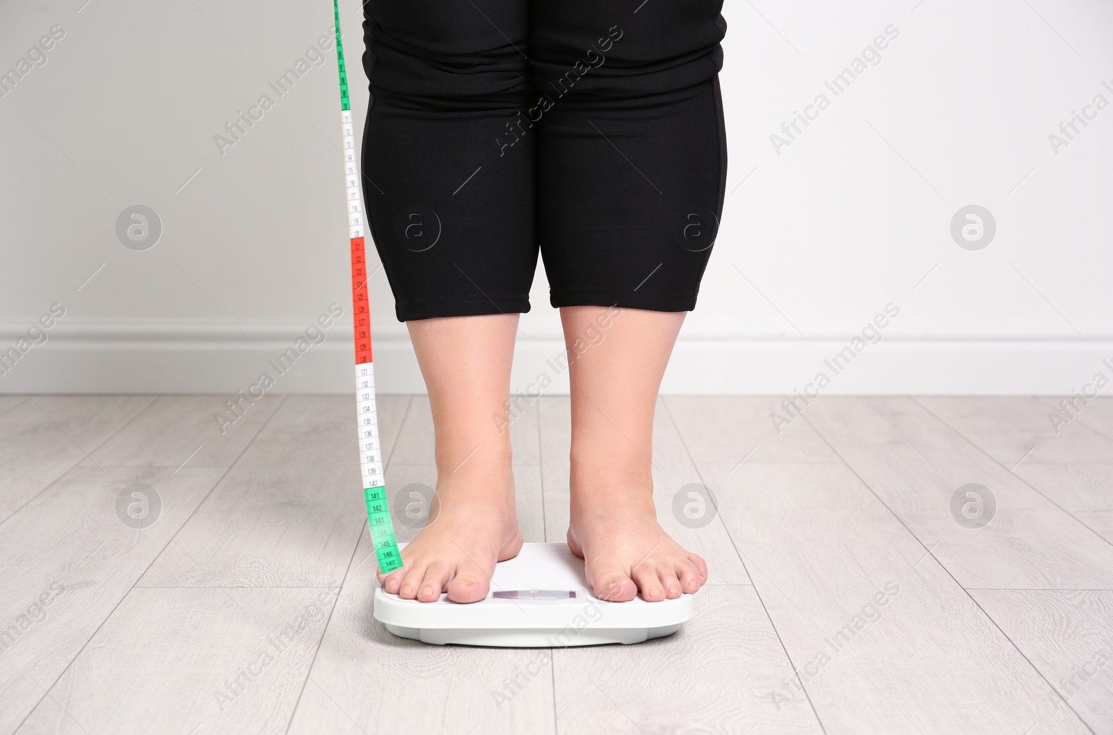 Photo of Overweight woman using scales indoors