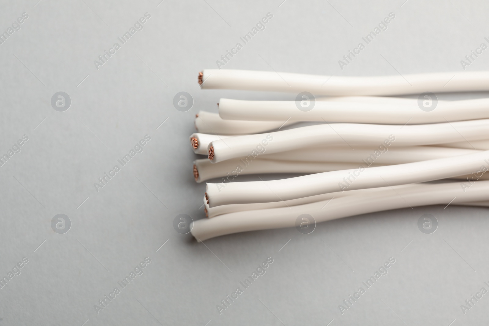 Photo of Many electrical cables on light background, closeup